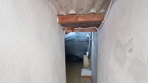 A narrow hallway with tiled flooring and a wooden ceiling beam. - Casa Fedafa  (Parghelia)