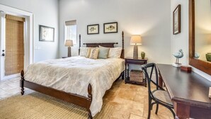 A bedroom with a bed, bedside tables, a chair, and artwork on the walls. - Marlin Haven @ Holiday Isle (Destin)