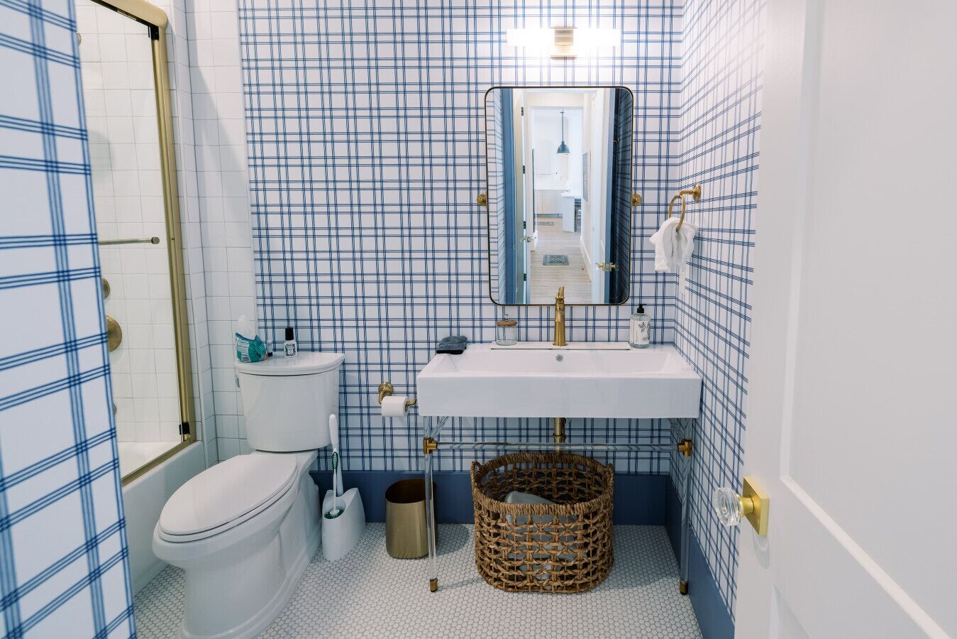 A bathroom with a toilet, sink, and mirror.