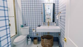 A bathroom with a toilet, sink, and mirror.