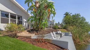 Une maison moderne dotée d’un patio, d’un petit jardin et d’un bassin.