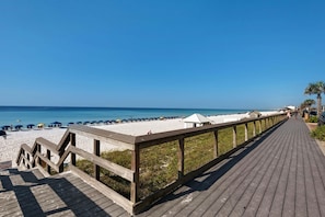 A wooden boardwalk leading to a beach with umbrellas and beach chairs. - Majestic Sun 1108b - Wave Whisper (Miramar Beach)