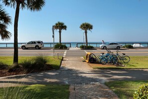 A paved walkway with a bike rack and parked cars along a coastal road. - Majestic Sun 312b - 3 Tortugas (Miramar Beach)