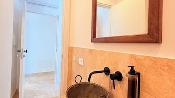 Ein Badezimmer mit Waschbecken, Spiegel und Dusche.