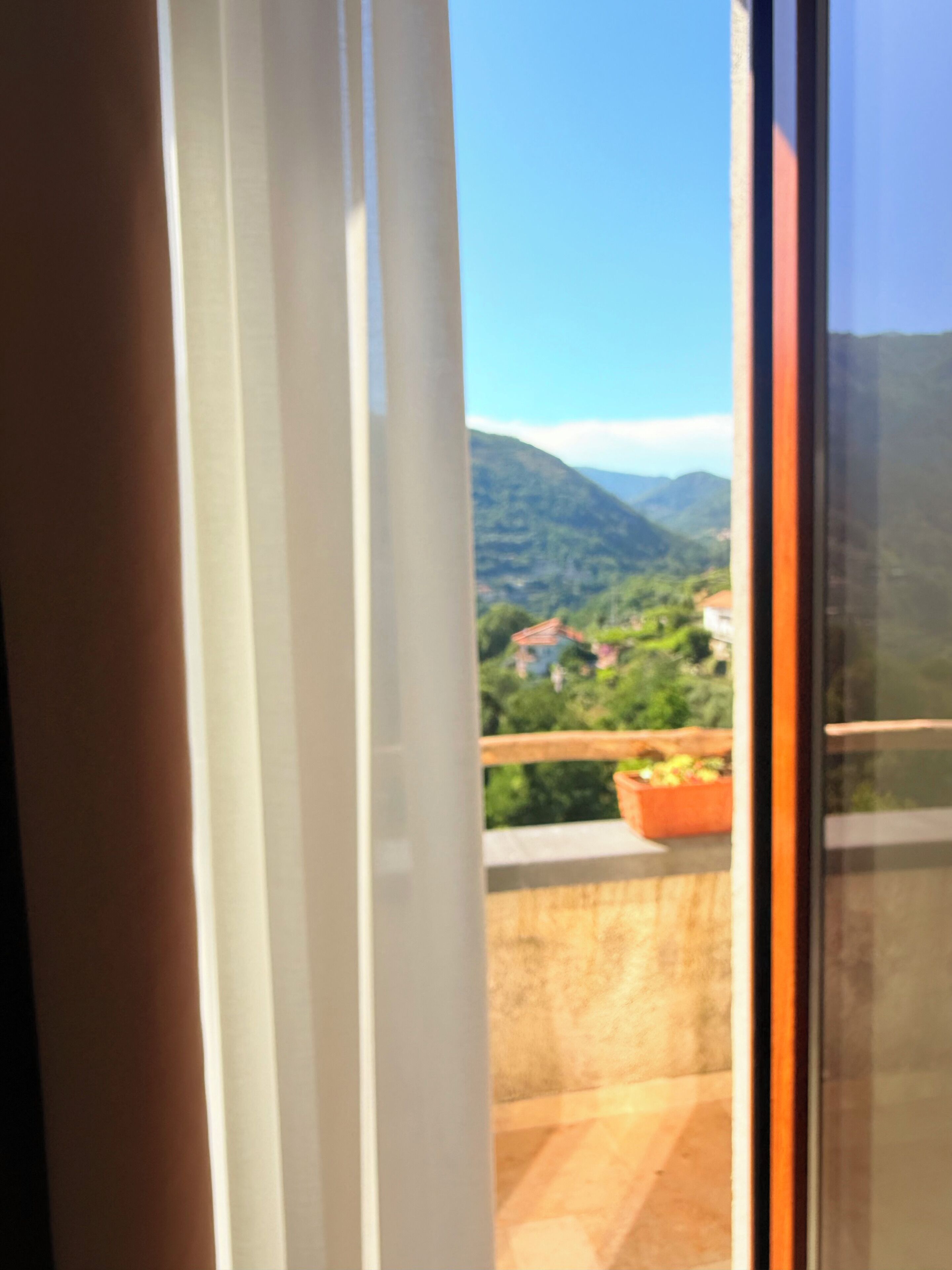 Een balkon met uitzicht op een bergachtig landschap.
