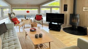 Ein gemütliches Wohnzimmer mit einer Couch, einem Couchtisch, einem Fernseher und einem Kamin.