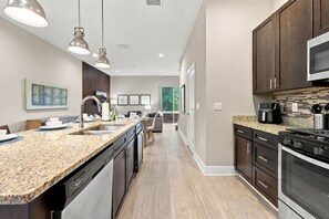 A modern kitchen with granite countertops, stainless steel appliances, and pendant lighting. - Family Retreat with 4Bed suites & Private Jacuzzi (Four Corners)