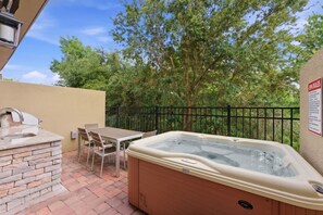 An outdoor patio with a hot tub, a stone-built sink, and a table with chairs. - Family Retreat with 4Bed suites & Private Jacuzzi (Four Corners)