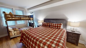 A bedroom with a bunk bed, a single bed, a nightstand with a lamp, and a dresser. - NEW! Seneca 213 - Brigham One Bedroom Plus Condo (Snowshoe)