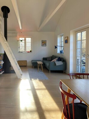 Ein Wohnzimmer mit Treppe, Sofa, Tisch und Bücherregal.