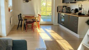 Una cocina moderna con comedor, un sofá y un ventanal grande.