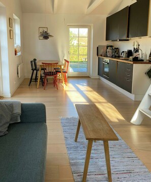 Eine moderne Küche mit Essbereich, einer Couch und einem großen Fenster.