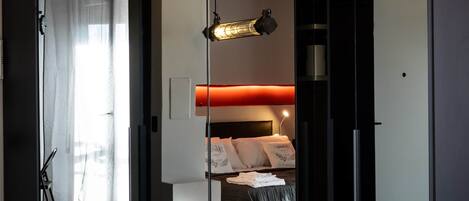 Une chambre à coucher moderne avec un lit, une table de chevet et un miroir.