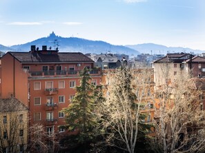 A residential area with multi-story buildings, some with balconies, and a mountain in the background. - CARLOTTA STATION SUITE (Bologna)