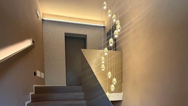 Eine moderne Treppe mit Holzstufen und einem geometrischen Wanddekor.