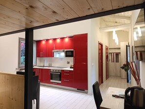 Una cocina moderna con armarios rojos, un microondas y un lavamanos.