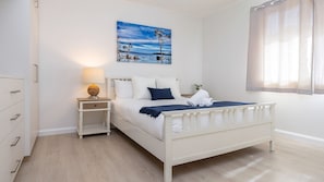 Une chambre à coucher avec un lit, une table de chevet, une lampe et un tableau au mur.