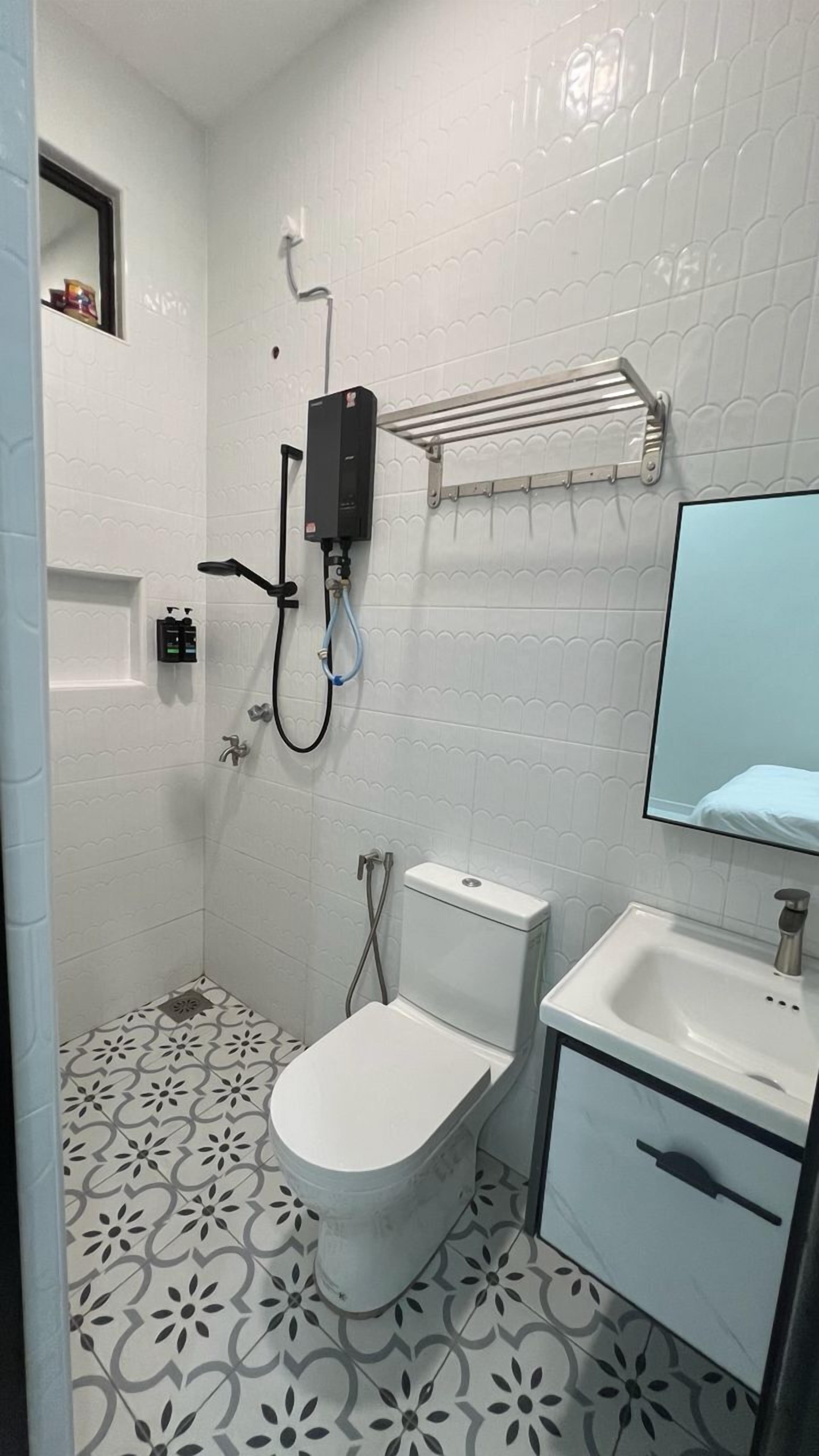 Un baño con inodoro, lavamanos y ducha.