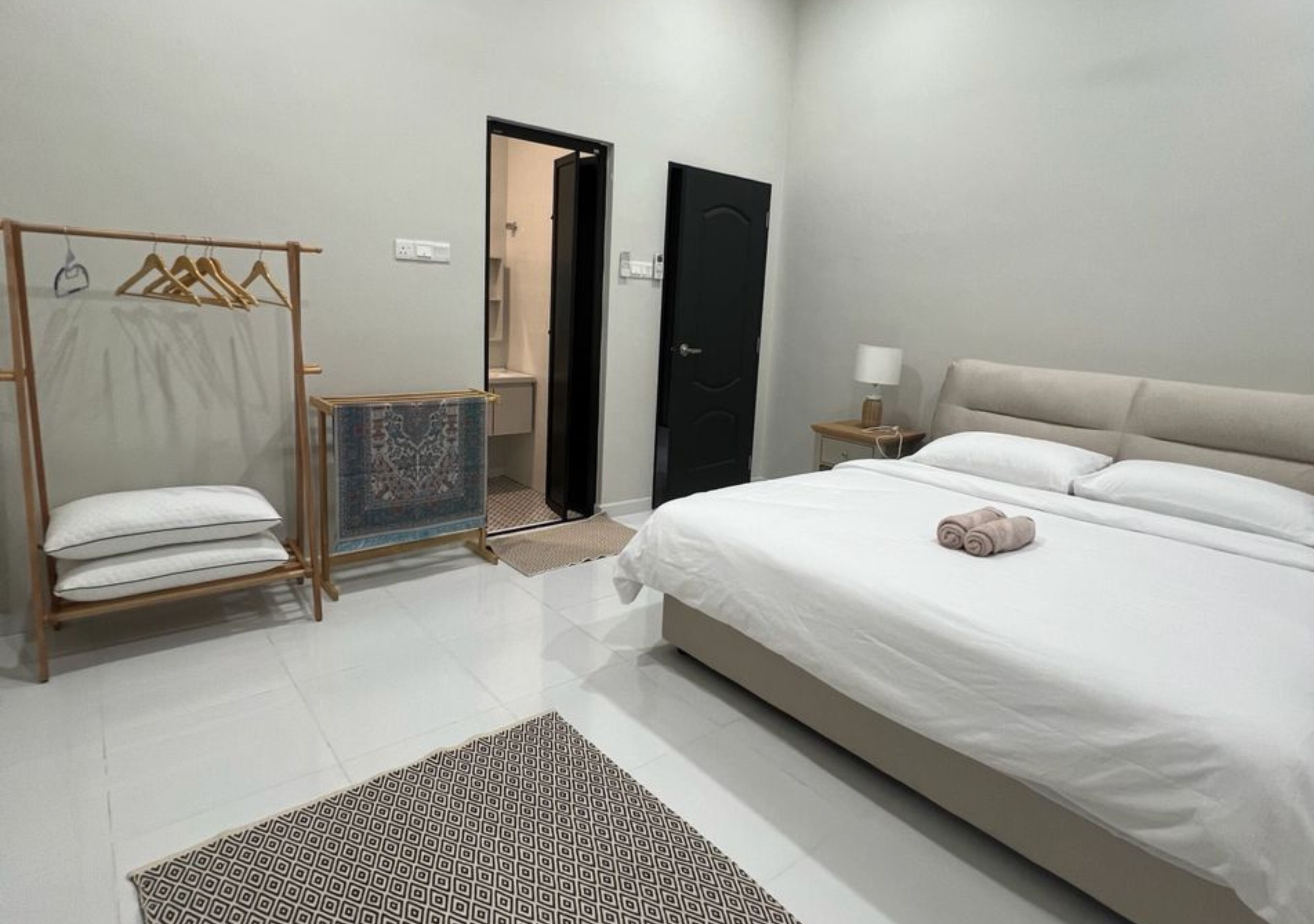 A bedroom with a bed, a wardrobe, a door, and a nightstand.