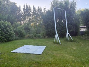 Ein grünes Areal im Freien mit einer Metallkonstruktion und einer Matte.