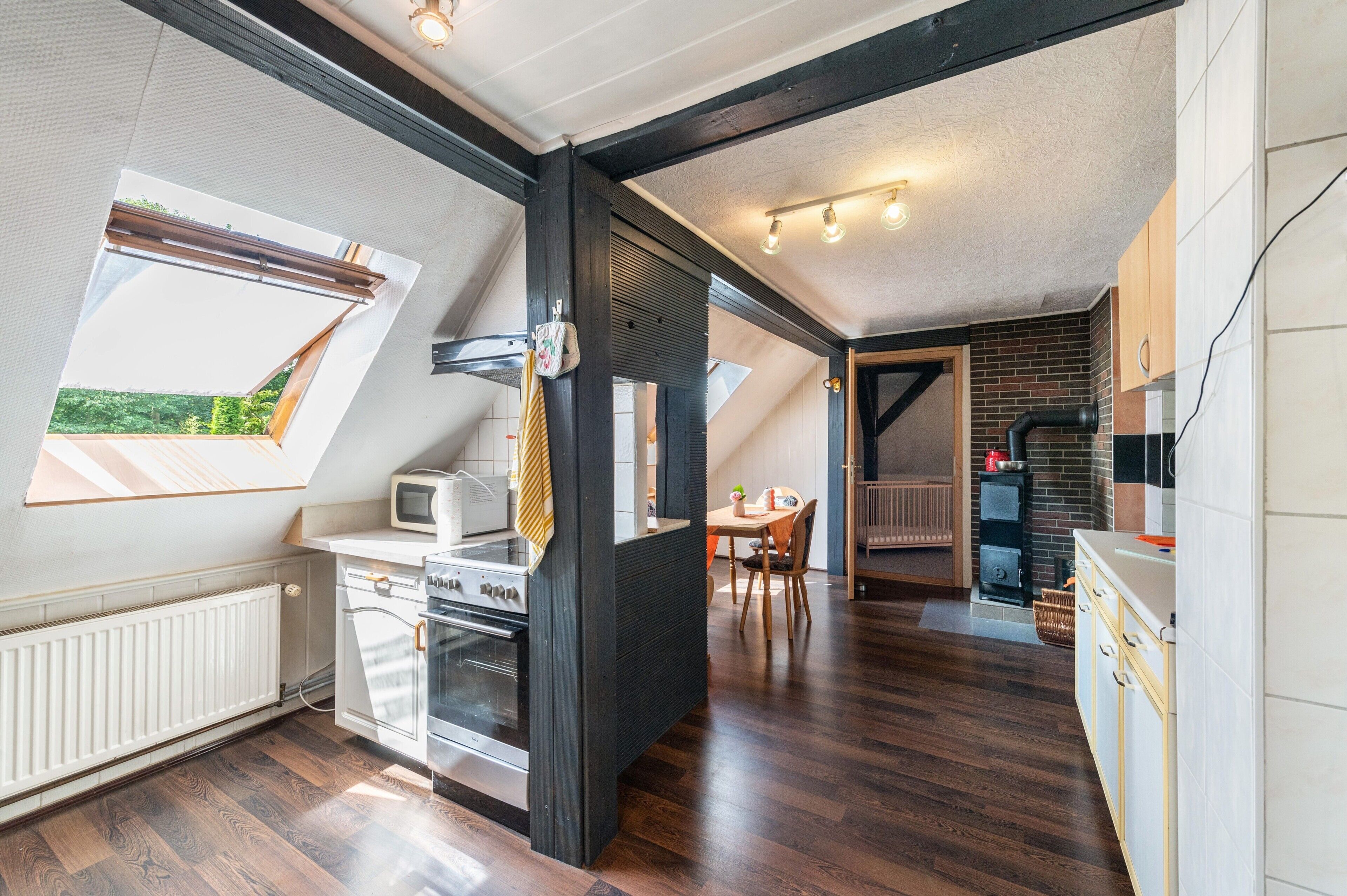 A modern kitchen with a built-in oven, microwave, and a dining area with a table and chairs.