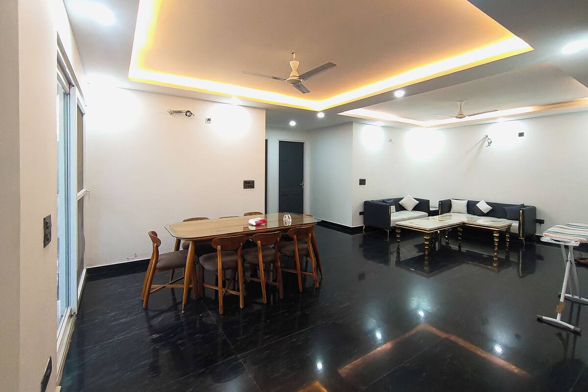 Un salon moderne avec un coin repas, un ventilateur de plafond et un canapé.