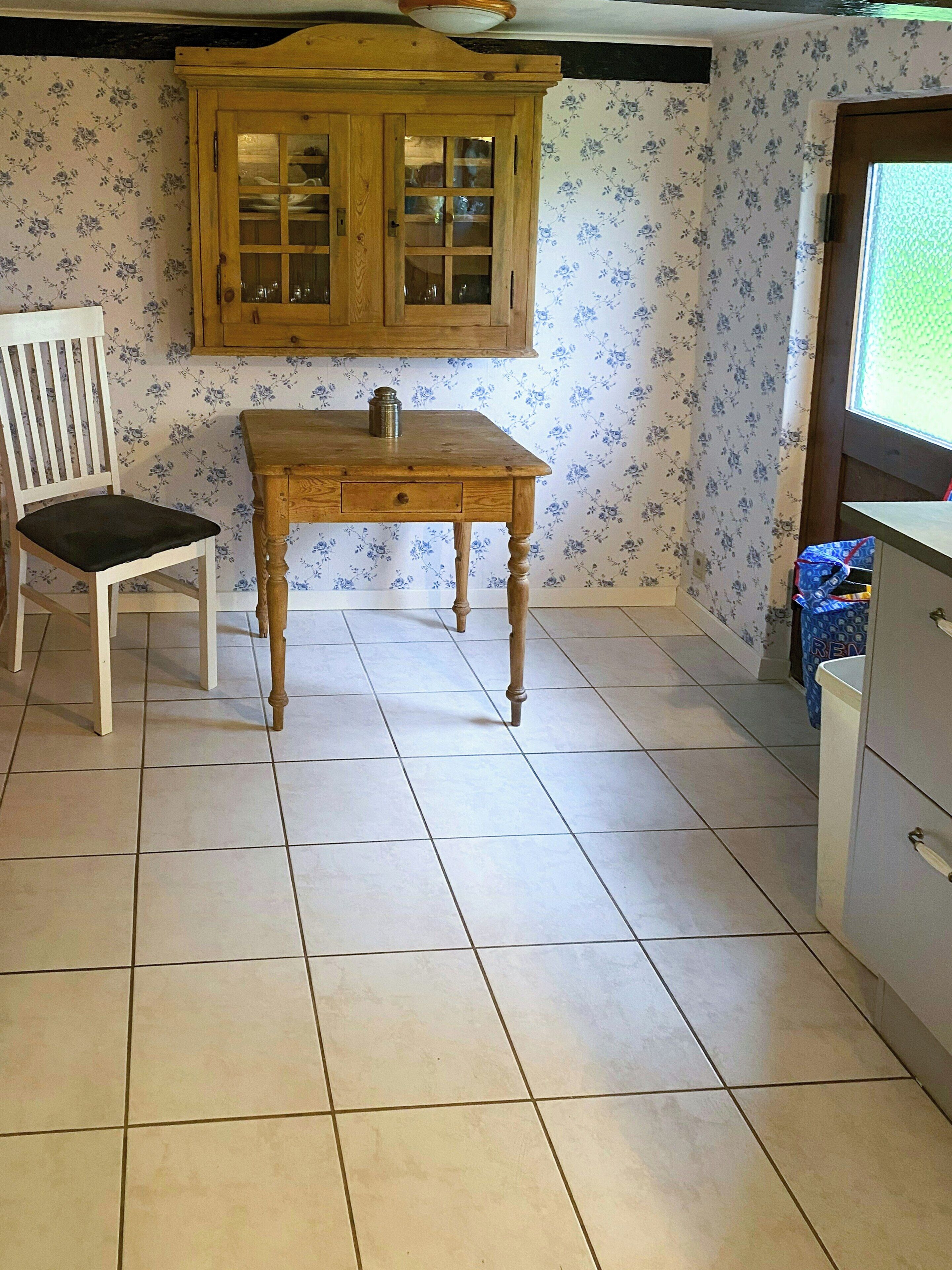 Una habitación con un armario de madera, una silla y una mesa.