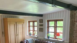 Una sala de estar acogedora con un sofá de cuero, una mesa de centro de madera y un mueble aparador grande.