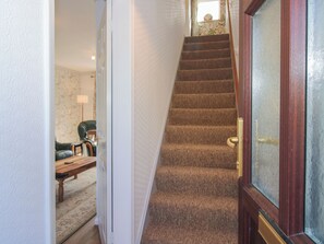 A carpeted staircase with a wooden handrail and a glass door with a brass handle. - Onny Views (Craven Arms)