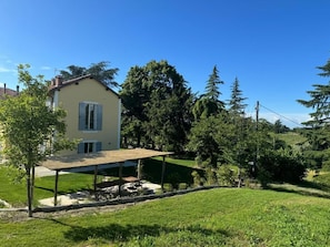 A house with a covered patio, a lawn, and surrounding trees. - La Torre Granaia (Novi Ligure)