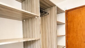 Un vestidor con varios estantes y una puerta de madera.