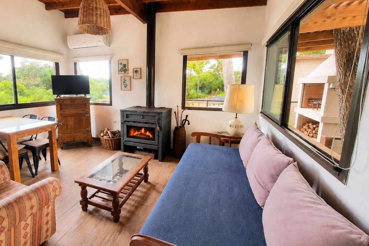 Una sala acogedora con un sofá, sillas, una mesita de centro, chimenea y televisión.