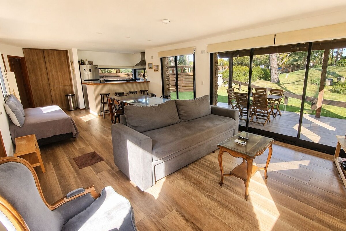 A modern living room with a sofa, coffee table, and dining area.