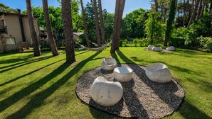 A well-maintained outdoor area with a circular seating arrangement and trees. - Complejo Playa Bonita Mar Azul 100m playa (Mar Azul)