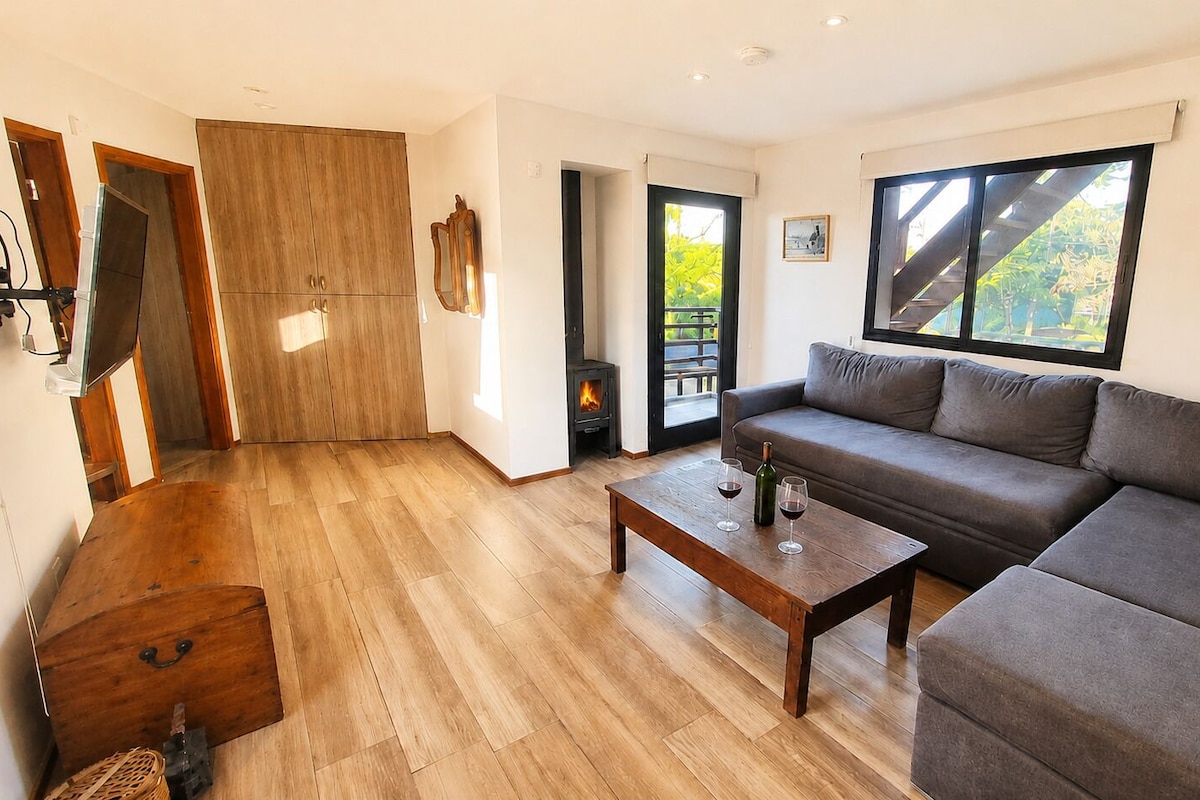 Una sala de estar con un sofá, una mesa de centro de madera y una chimenea.