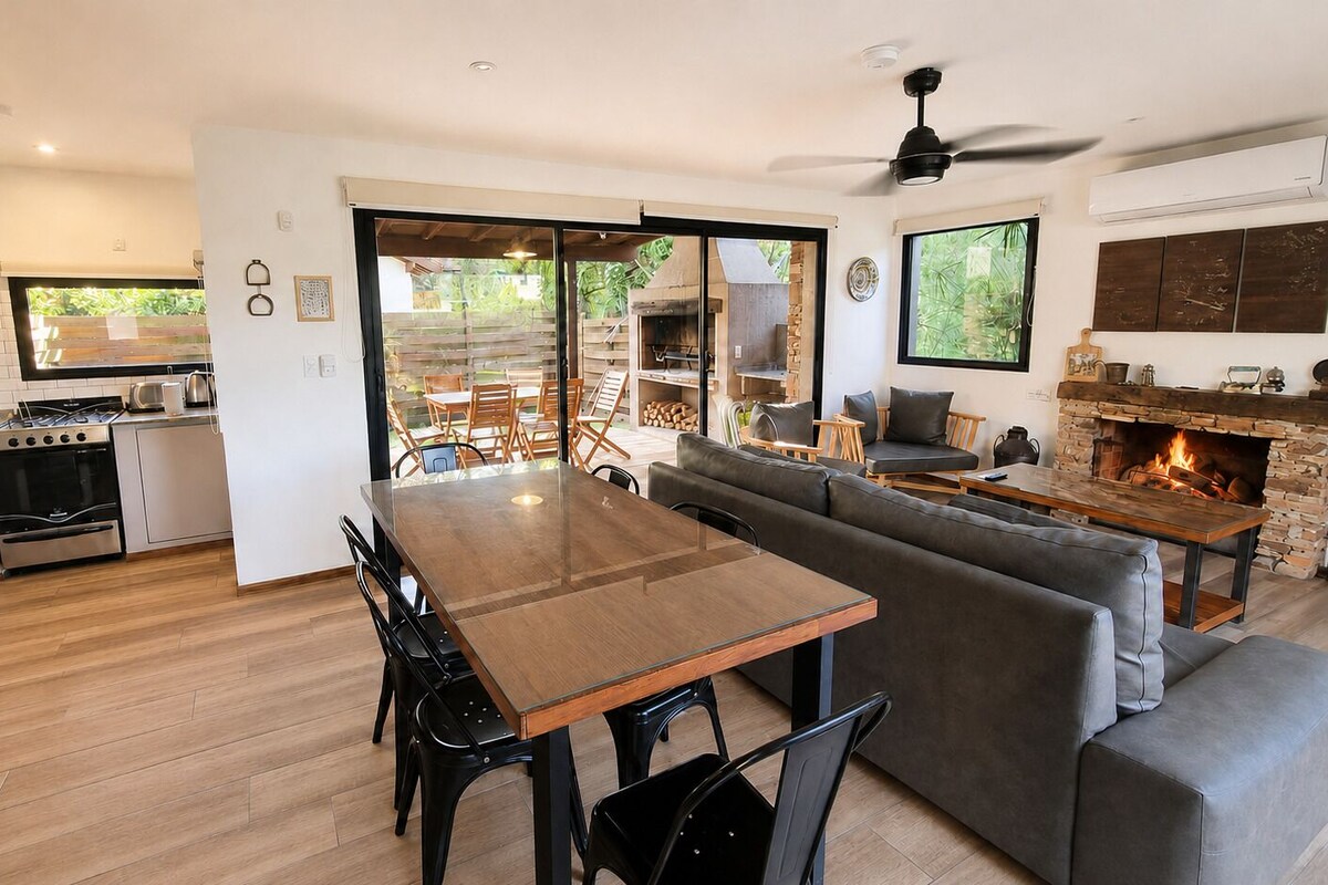 Una cocina moderna con comedor, chimenea y puerta corrediza de vidrio que da a un patio exterior.