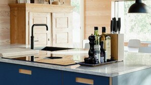Een moderne keuken met houten kastjes, een centraal eiland en een hangende吊灯