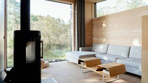 Een moderne woonkamer met een groot raam, een bank, een houten wand en een open haard.