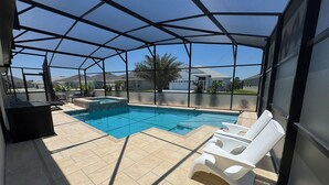 Ein überdachter Außenpool mit Whirlpool, Liegestühlen und einer Terrassenanlage.