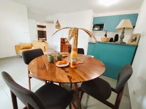 Ein Essbereich mit einem Holztisch, Stühlen und einer Flasche Tropicana Orangensaft.