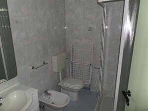 Ein Badezimmer mit Waschbecken, Bidet, Toilette und Duschkabine.