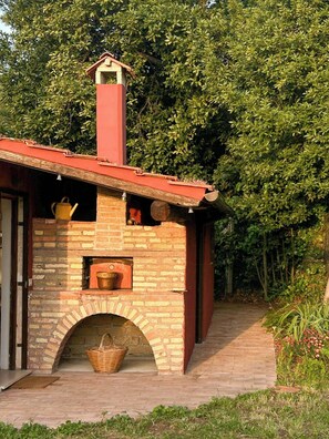 A brick building with a chimney, a small window, and a door. - 1927 house Rome's Appia Antica Park (Roma)