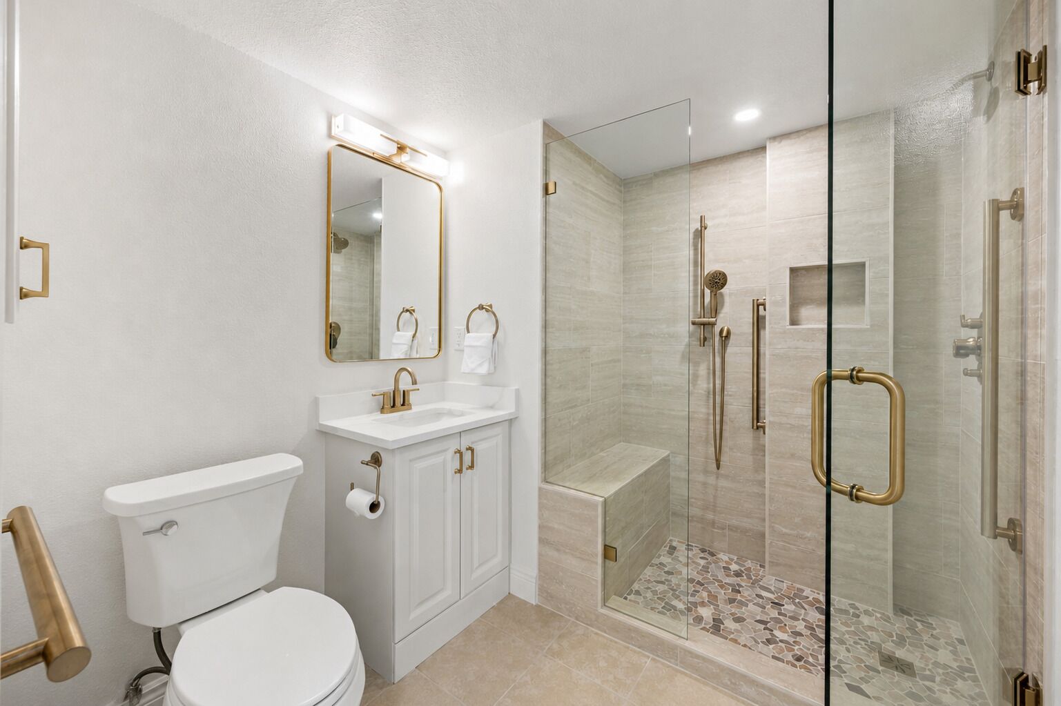 Een moderne badkamer met toilet, wastafel en douche.