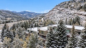 A resort with modern buildings surrounded by snow-covered trees and mountains. - Central Condo W/ Resort Amenities I Pool + Hot Tub (Vail)