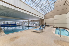 An indoor swimming pool with multiple lanes, lounge chairs, and a glass ceiling allowing natural light. - Central Condo W/ Resort Amenities I Pool + Hot Tub (Vail)