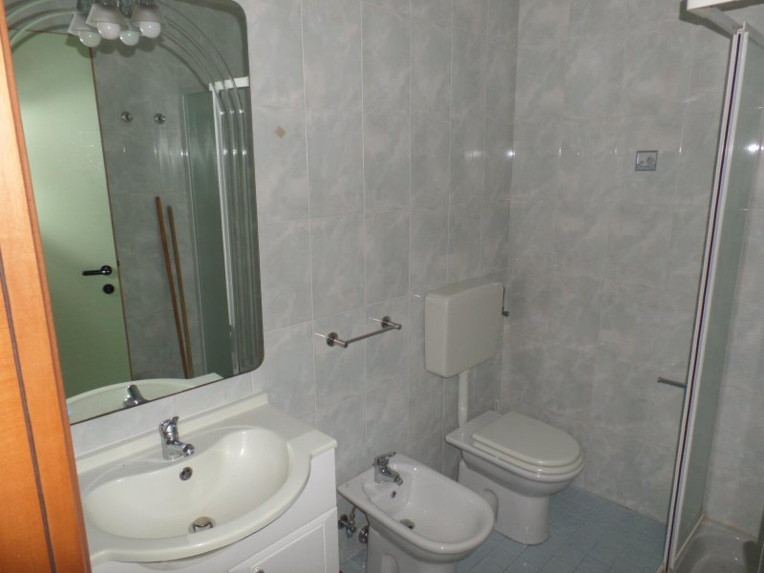 Ein Badezimmer mit Waschbecken, Bidet, Toilette und Spiegel.