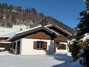 A chalet with a sloped roof, wooden exterior, and large windows. - PRAZ SUR ARLY Chalet, 5 minutes from MEGEVE—Come experience it for yourself (PRAZ SUR ARLY,)