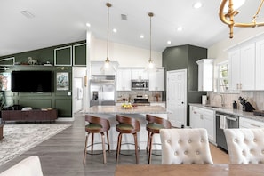 A modern kitchen with a central island, bar stools, and pendant lighting. - Horse Country Escape 15 Minutes to WEC & Adventure Springs (Ocala)