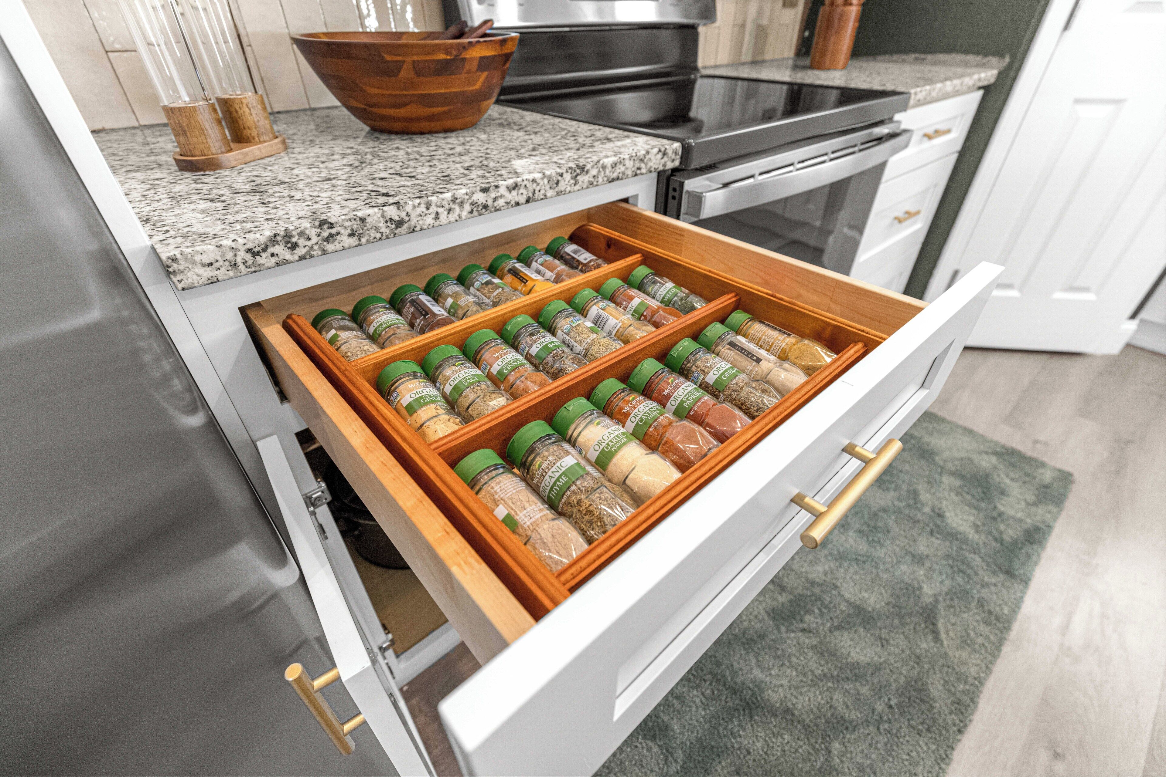 A kitchen drawer with multiple spice jars.