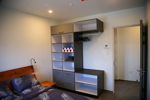 Ein Schlafzimmer mit Bett, Kleiderschrank und Tür.